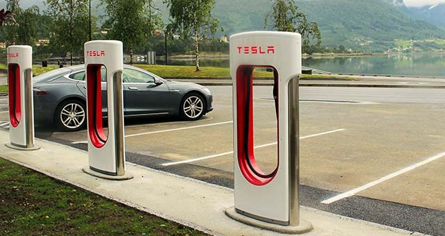 Photo d'une Tesla Model 3 sur le parking d'un Supercharger Tesla.