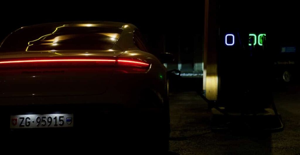 Porsche Taycan garé sur une place de parking de nuit