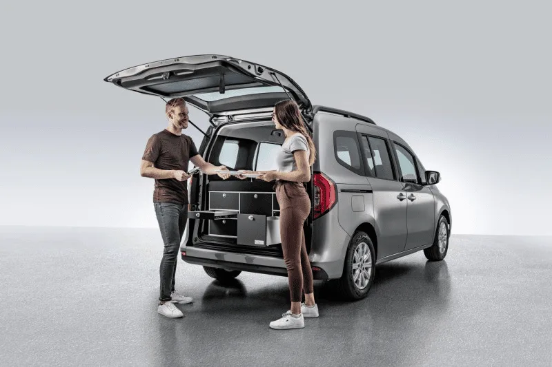 Photo promotionnelle présentant un couple profitant des fonctionnalités offertes par le Citan, avec le hayon ouvert, et l'accès aux divers rangements du véhicule.