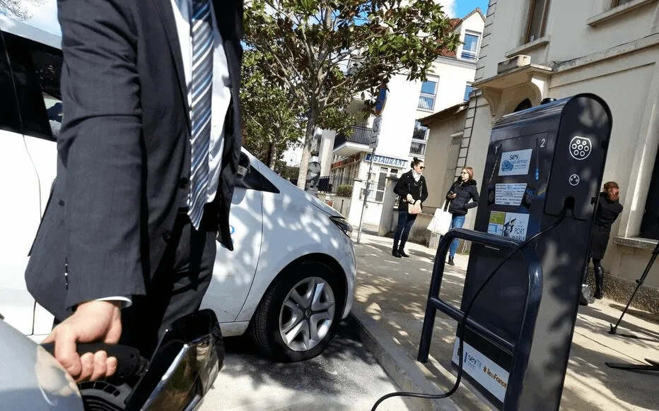 Photo d'un conducteur effectuant le recharge de son véhicule électrique sur une borne publique
