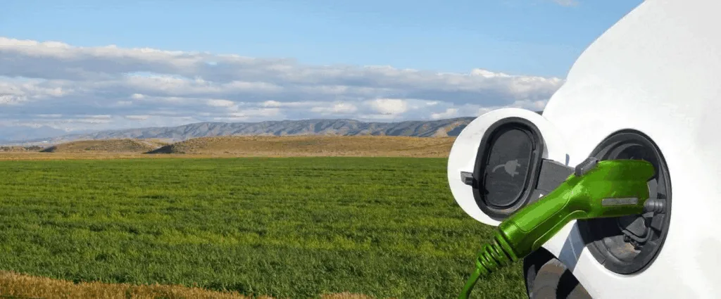 Photo de la prise de recharge d'un véhicule électrique, sur fond de paysage naturel