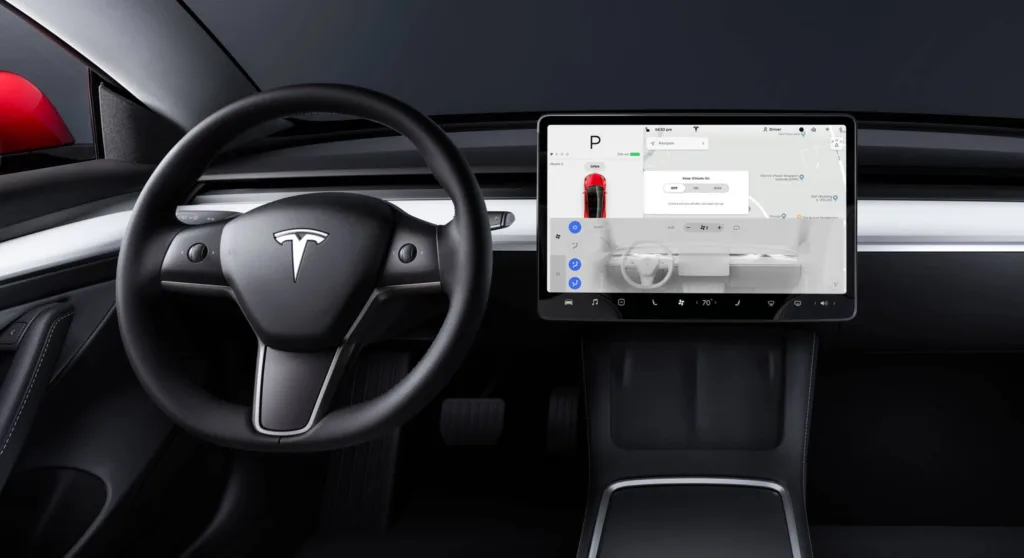 Photo montrant la vue depuis le siège conducteur d'une Tesla Model 3, mettant en avant l'importance de l'écran, à côté du volant.