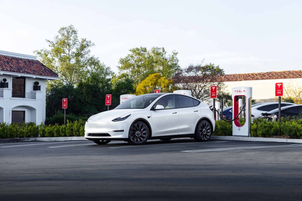 Photo d'un véhicule Tesla effectuant sa recharge à un superchargeur