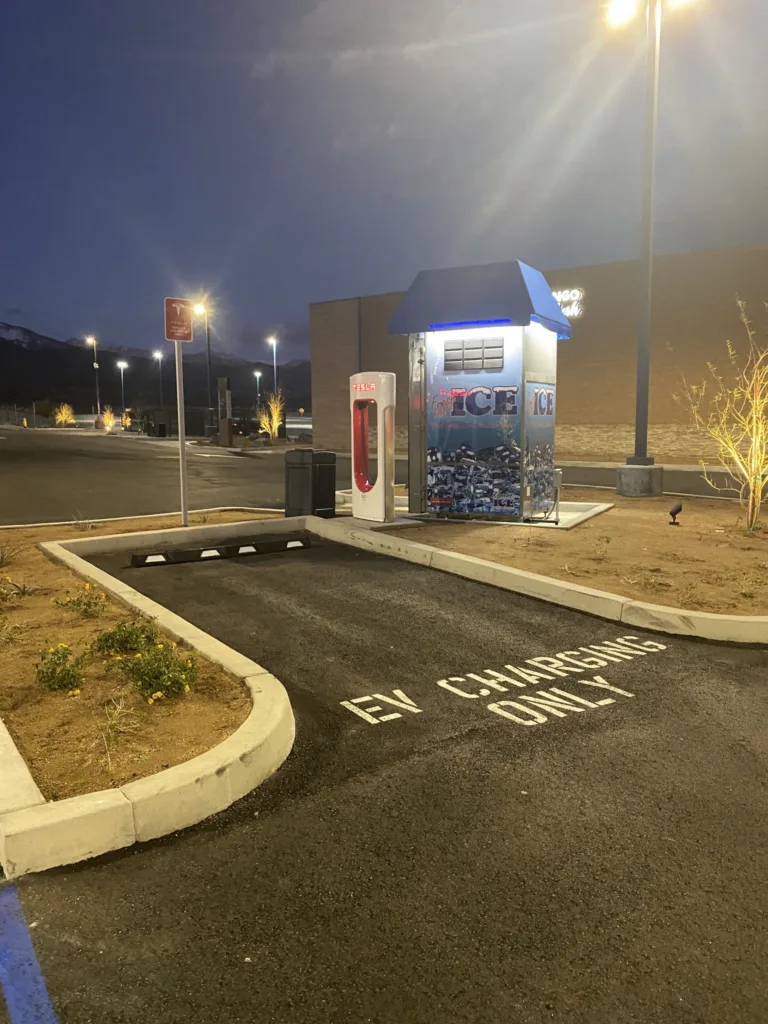 Photo d'une place de supercharger à côté de laquelle est installé un stand portant la mention "ICE"