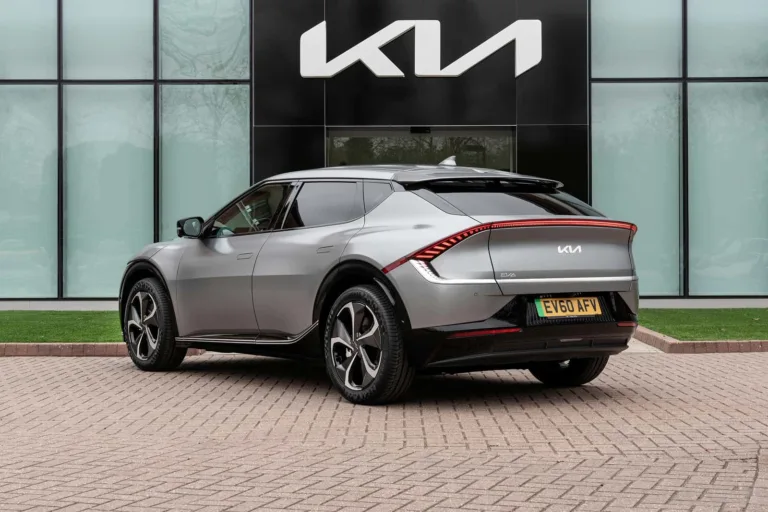 SUV Kia gris garé devant une concession Kia