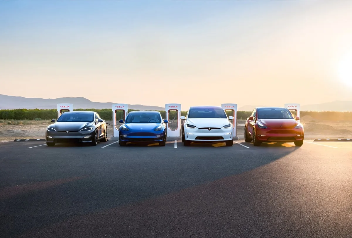 Gamme de voitures Tesla alignée au lever du soleil