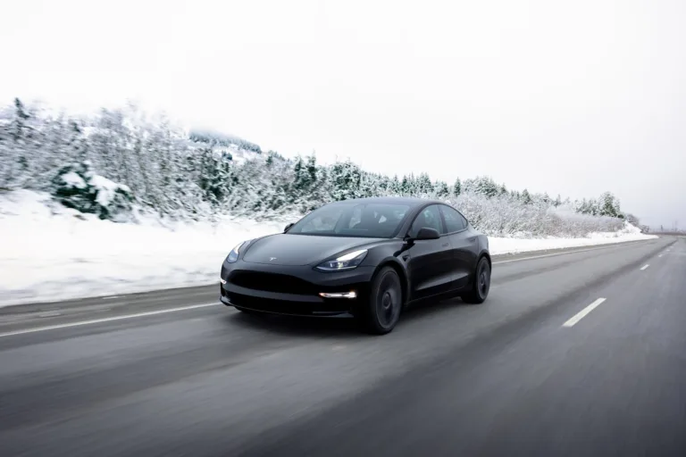 Tesla Model 3 noire sur route enneigée