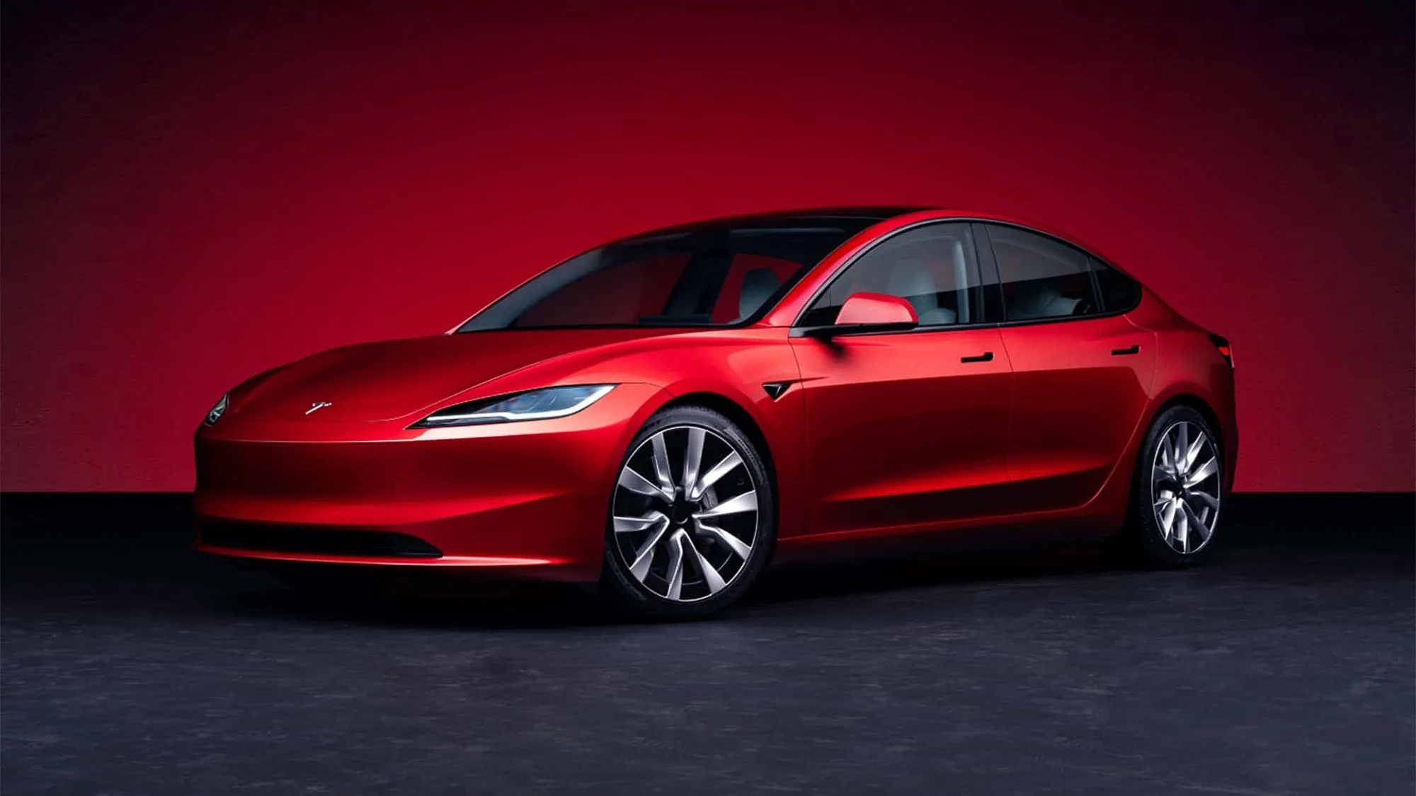 Tesla Model 3 rouge en studio, sur fond rouge