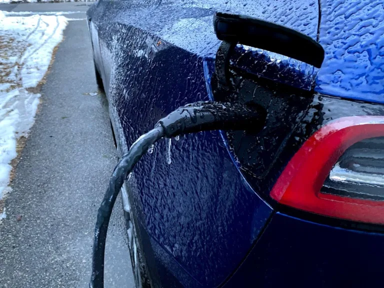 Tesla en recharge sous la pluie, prise branchée