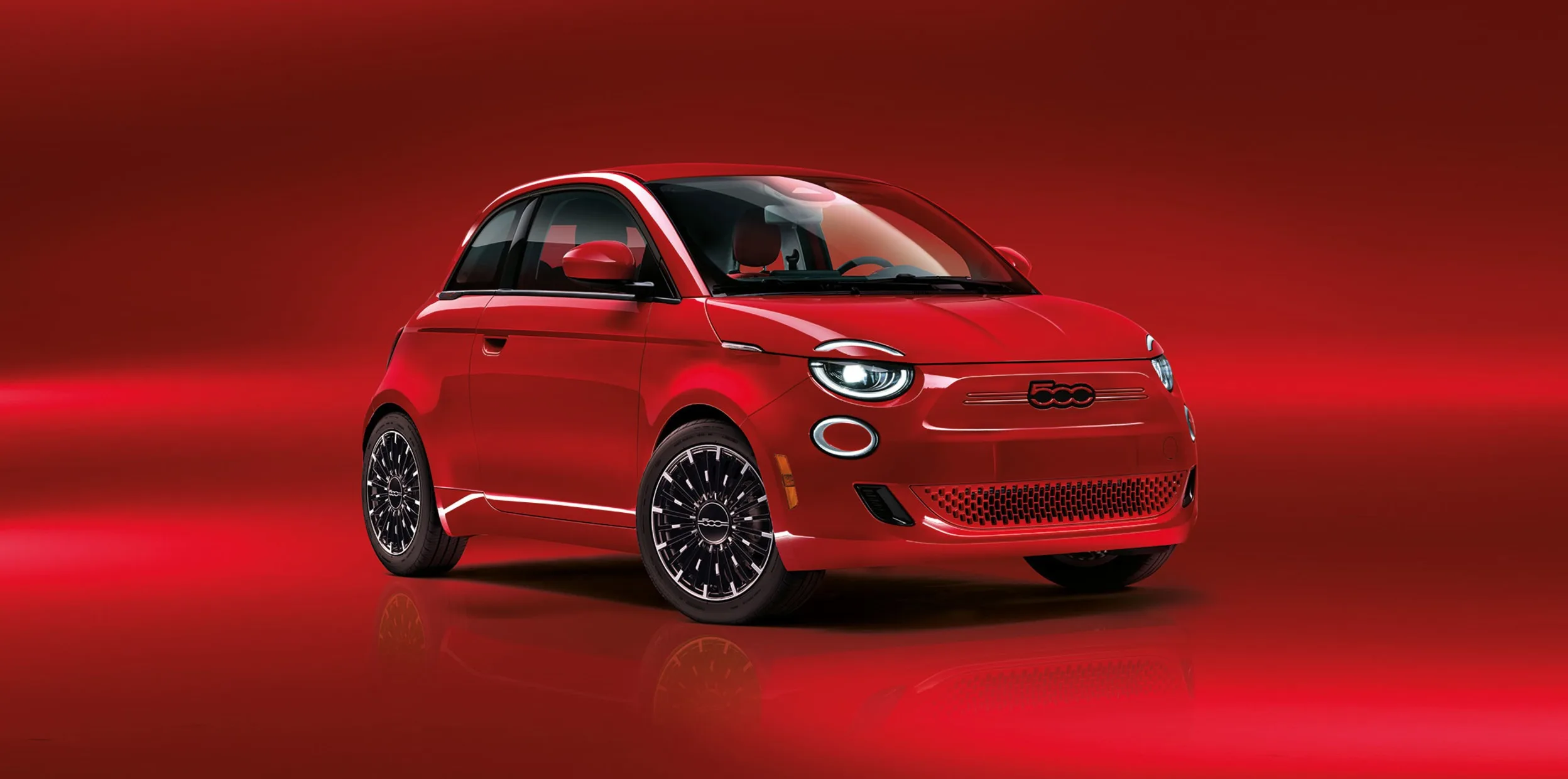 Fiat 500e rouge en studio, sur fond rouge