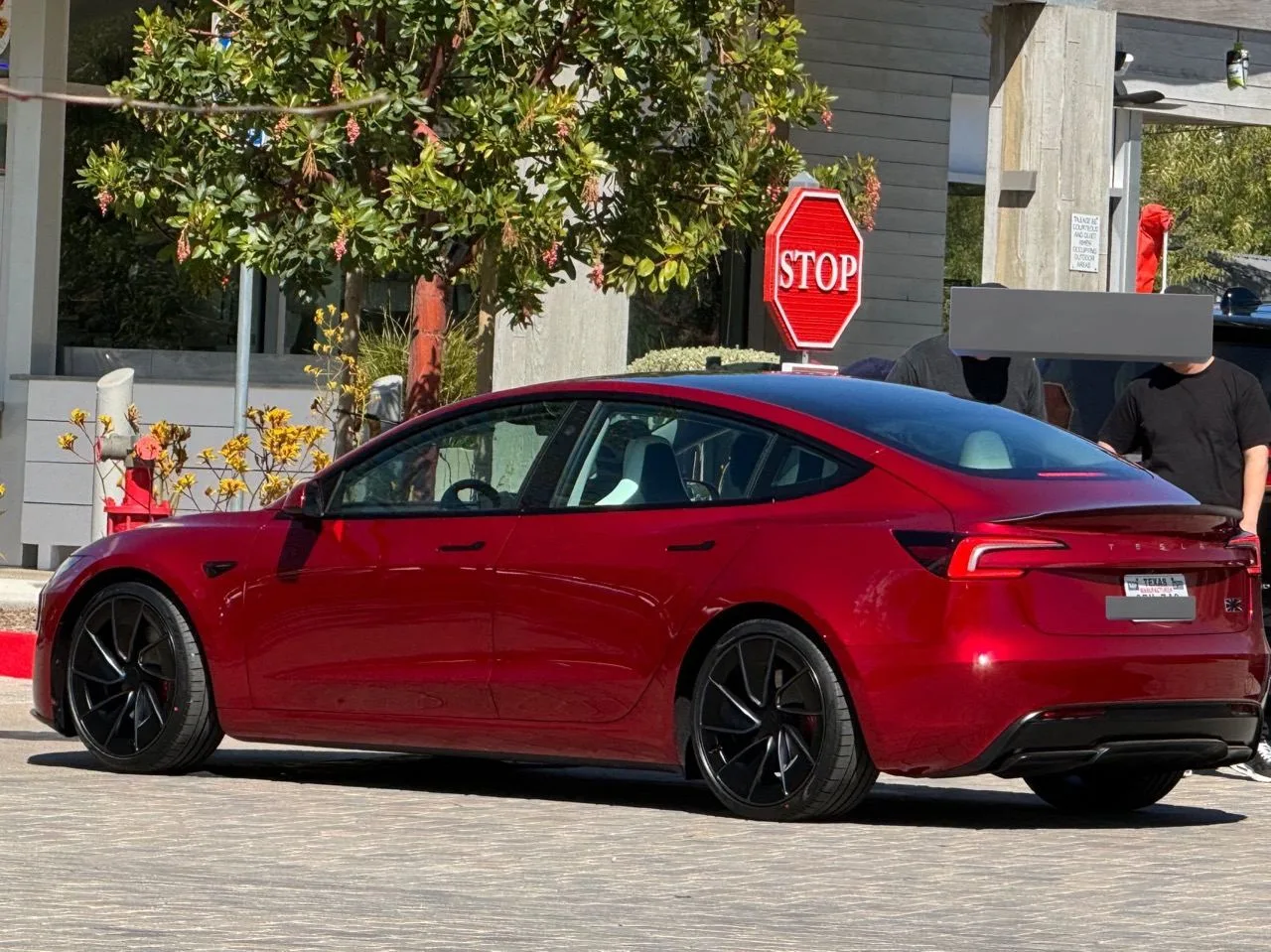 Tesla rouge garée devant un magasin Tesla