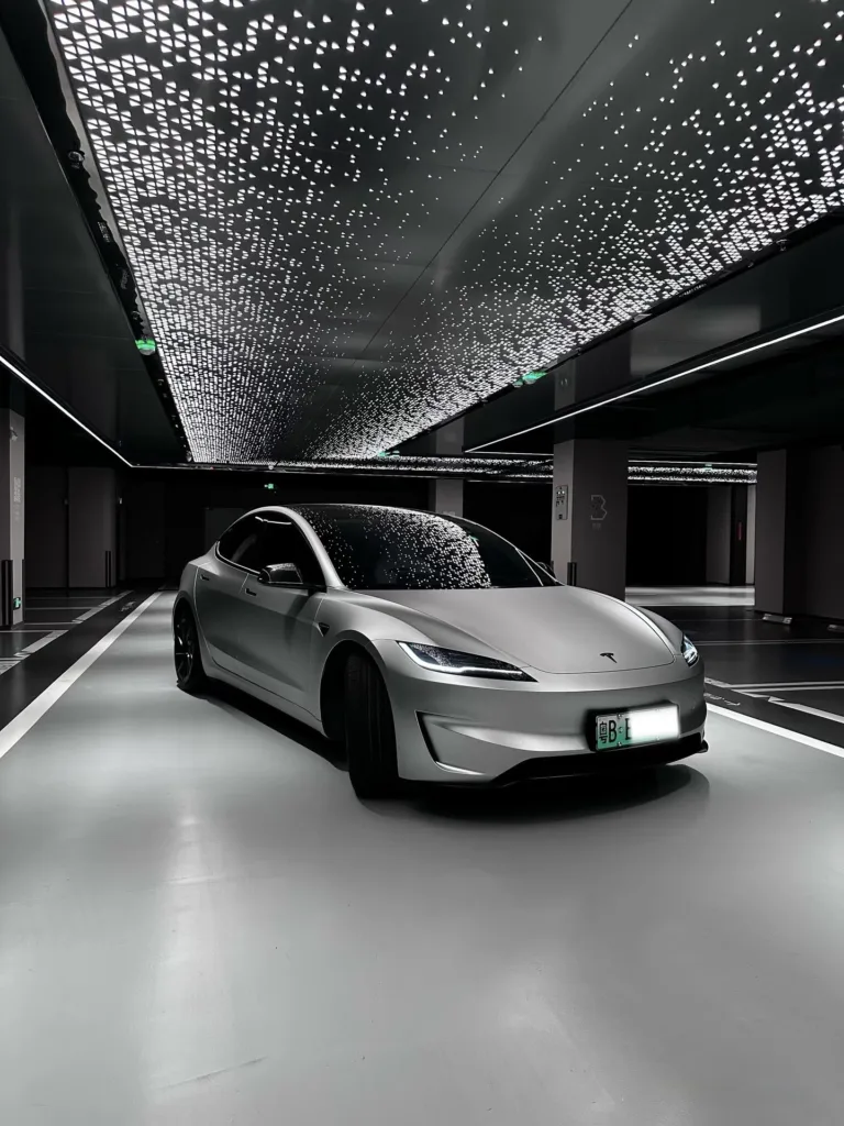 Tesla Model 3 Performance grise sous un plafond lumineux étoilé