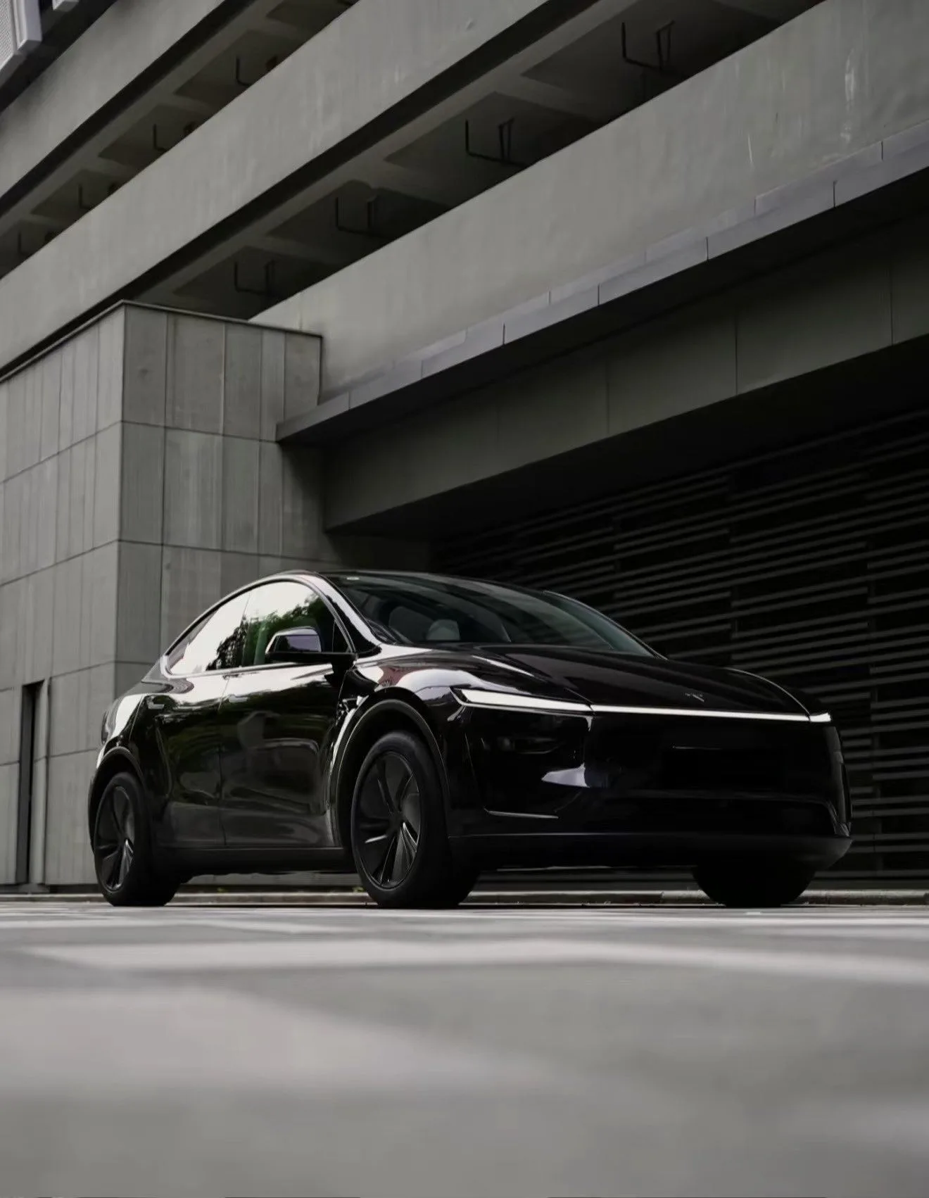Tesla Model Y en Noir Diamant sous un pont en béton