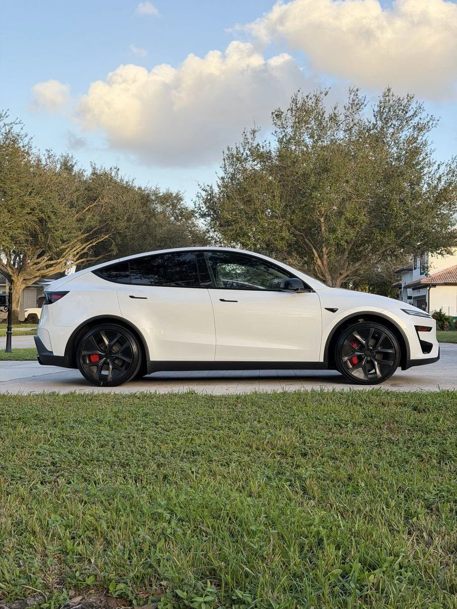 Tesla Model Y Performance blanche garée près d'oliviers
