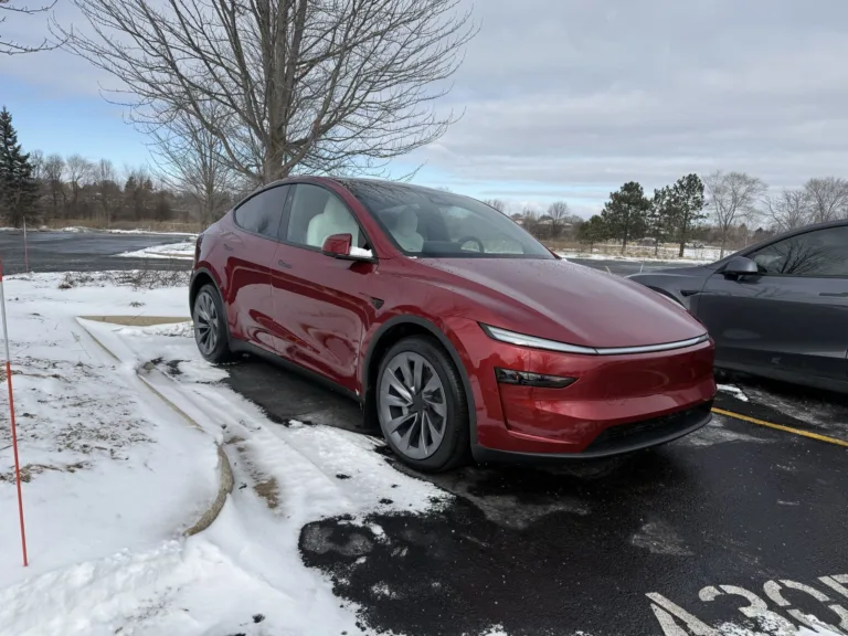 Tesla Model Y rouge garée sur un parking enneigé