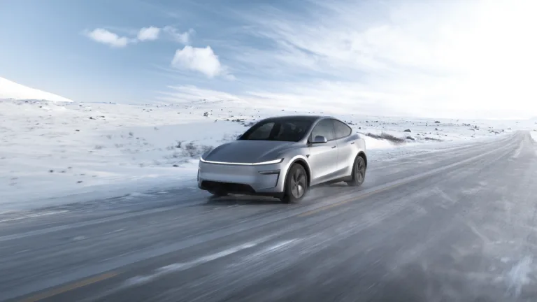Tesla Model Y blanche roulant sur une route enneigée