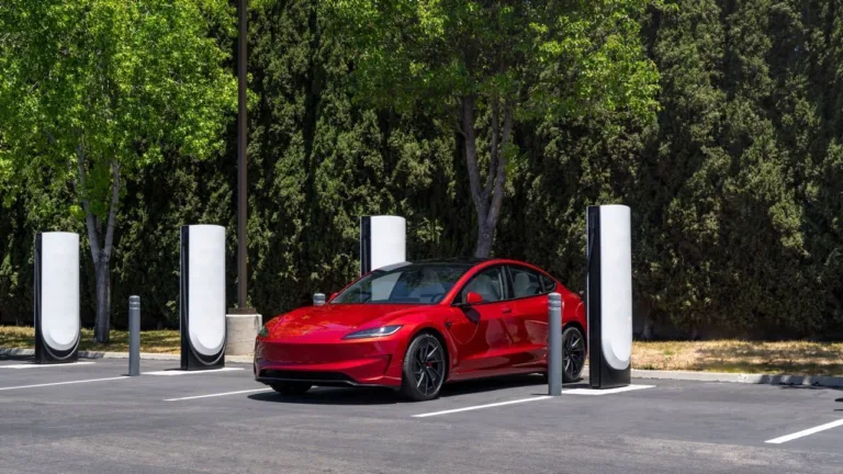 Tesla Model 3 rouge en recharge sur une station Superchargeur