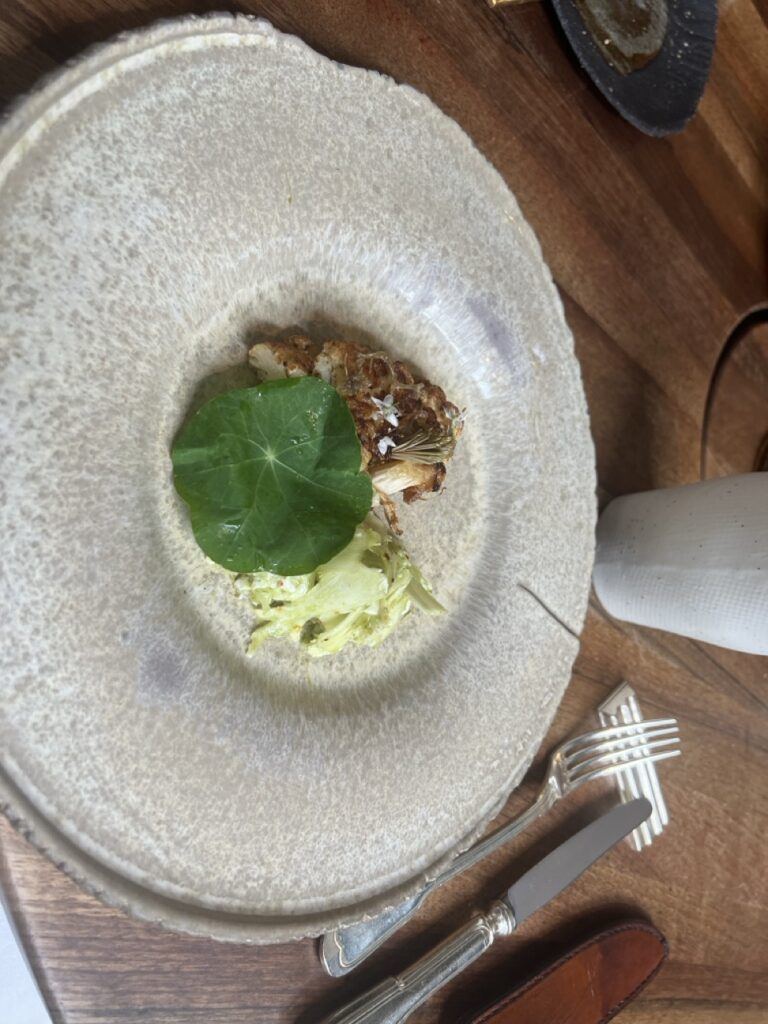 Déclinaison de chou-fleur rôti sous une grande feuille verte