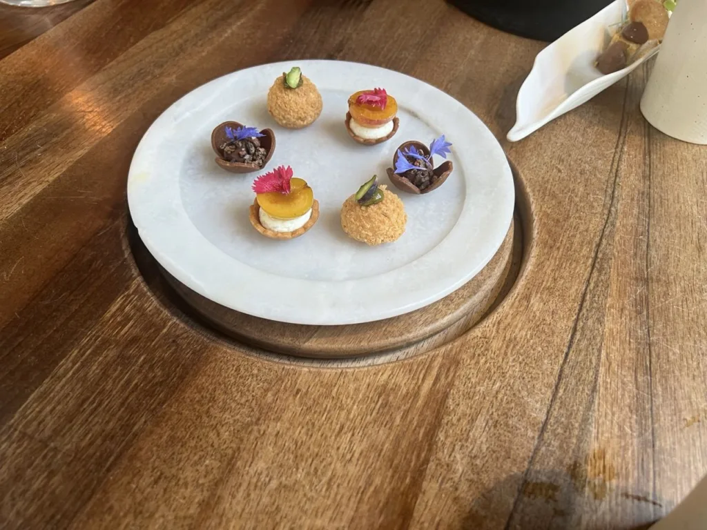 Mignardises : tartelettes aux fleurs, choux au praliné pistache, ganaches au chocolat