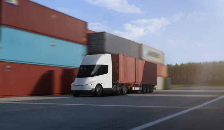 Un Tesla Semi tractant un conteneur sur une plateforme logistique