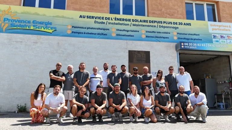 Groupe posant devant le siège de Provence Énergie Solaire Services, à La Ciotat, sous l’enseigne « Au service de l’énergie solaire depuis plus de 20 ans »