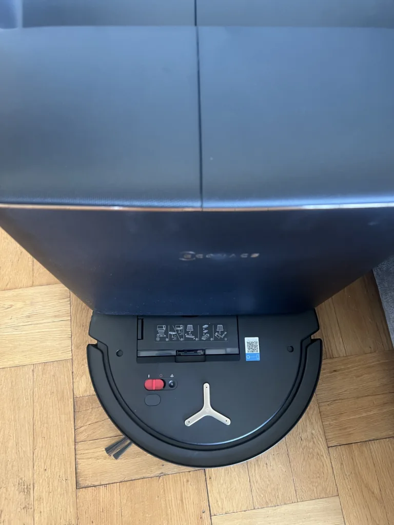 Le DEEBOT T90S garé sur sa station, sur un parquet
