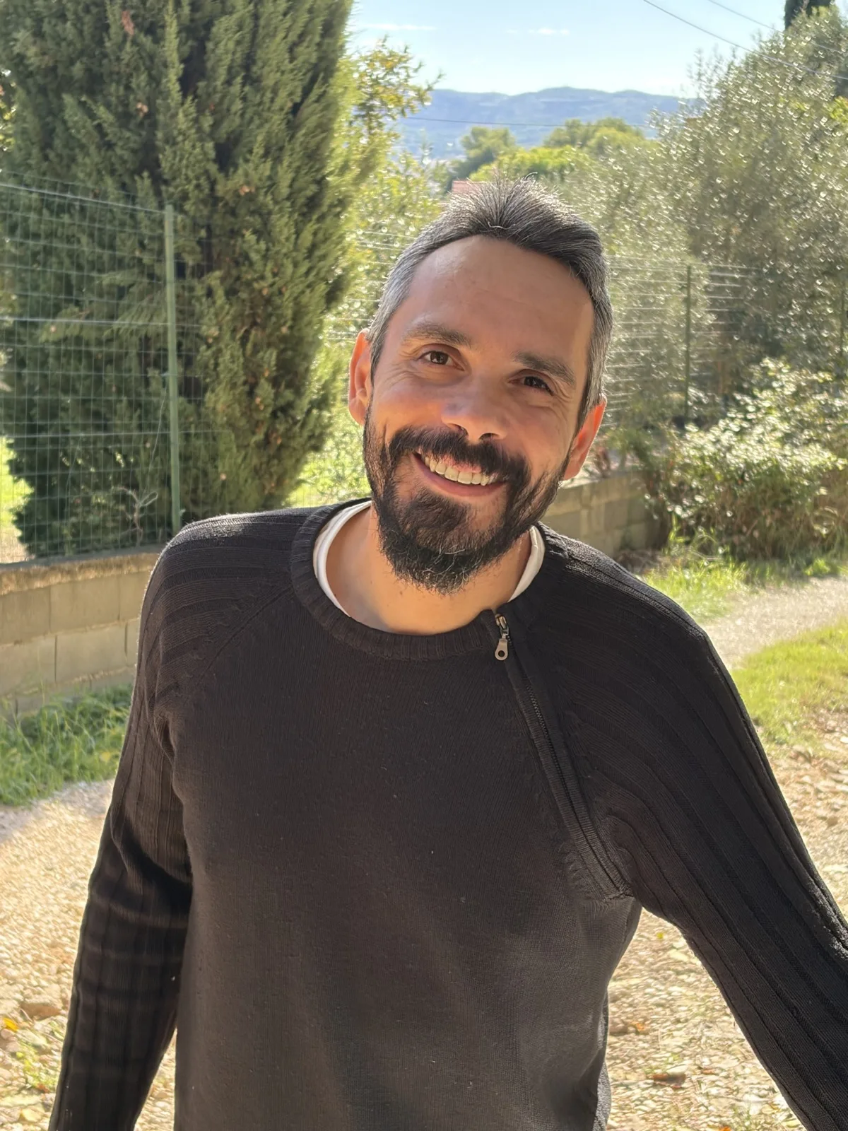 Hugo Hautenberger, cogérant et électricien de HBE, souriant, dans un jardin du Var