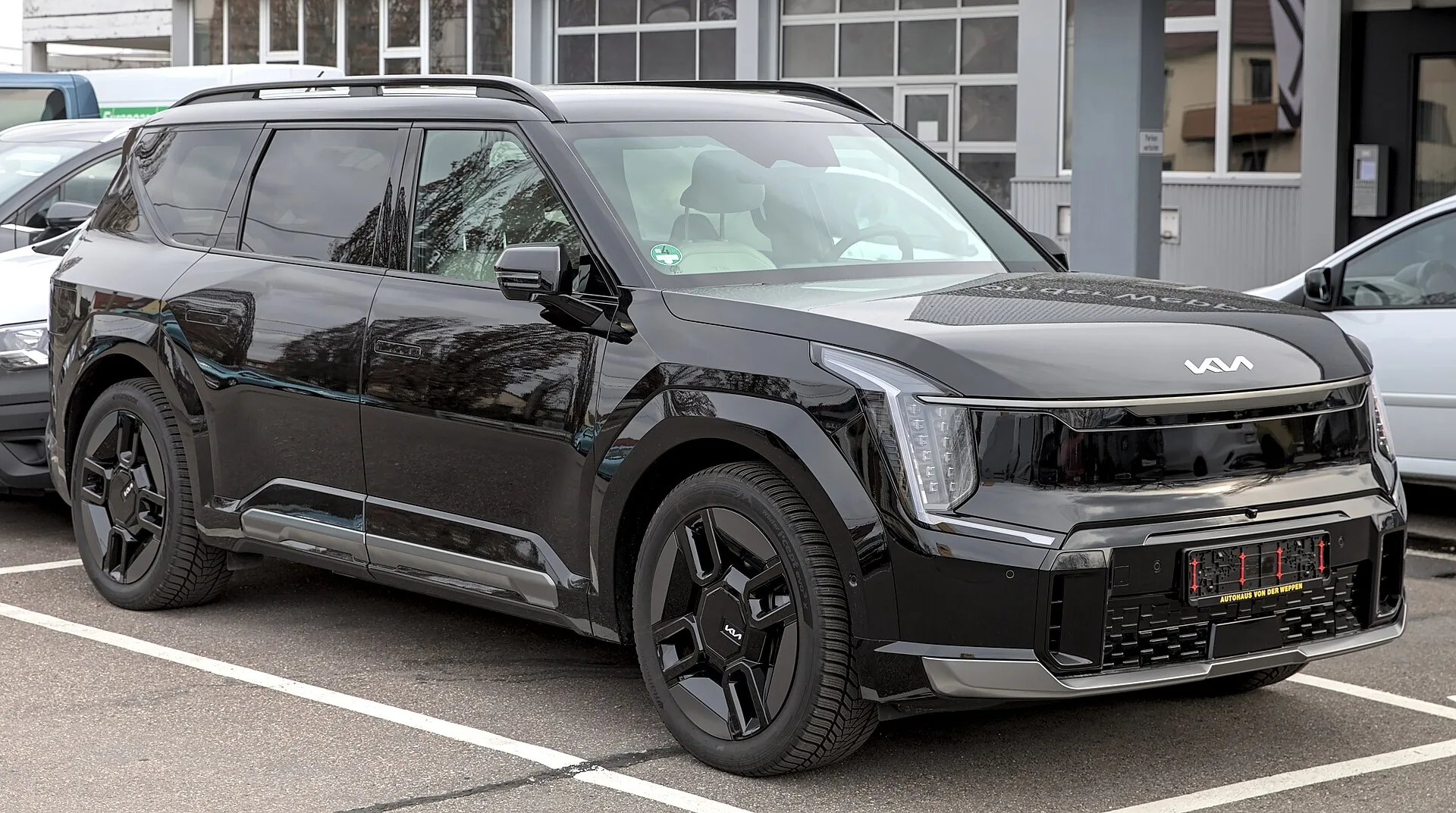 Un Kia EV9 GT-Line noir, SUV électrique 7 places, sur un parking