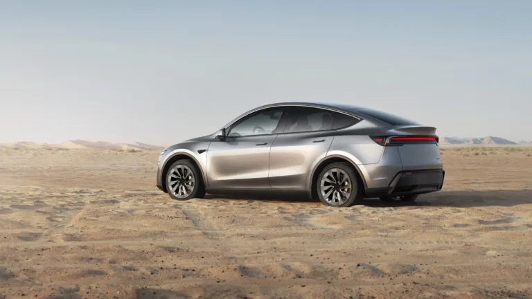 Tesla Model Y gris argent vu de profil sur un terrain sec