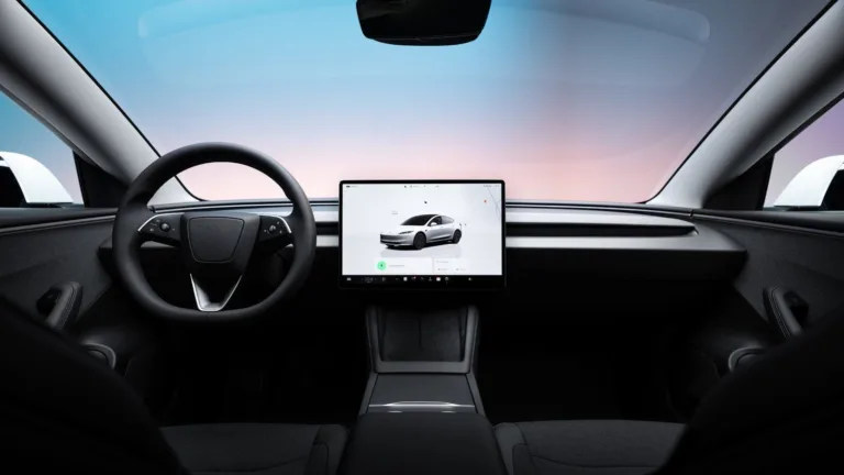 Tableau de bord et écran tactile central d’une Tesla Model 3, vus depuis la banquette arrière