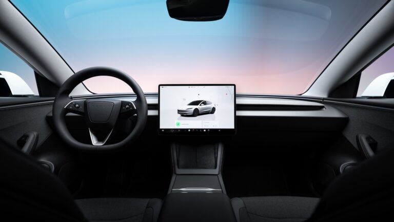 Tableau de bord et écran tactile central d’une Tesla Model 3, vus depuis la banquette arrière