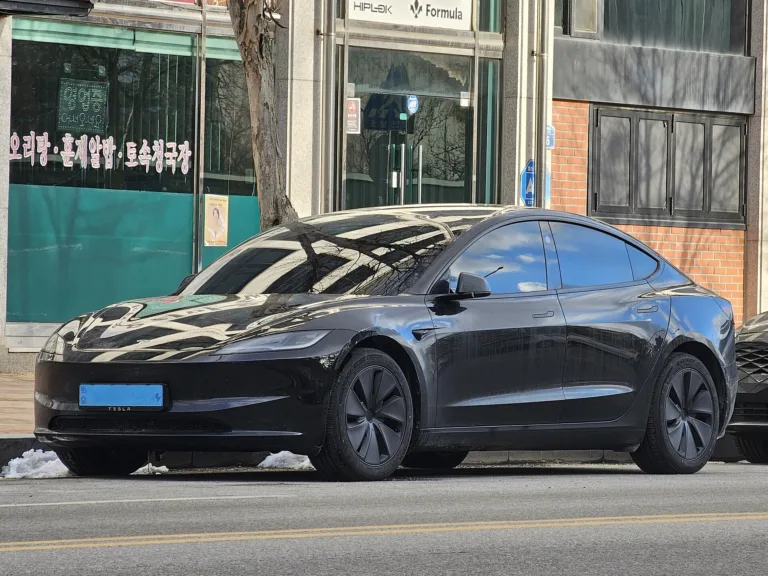 Une Tesla Model 3 noire stationnée dans une rue