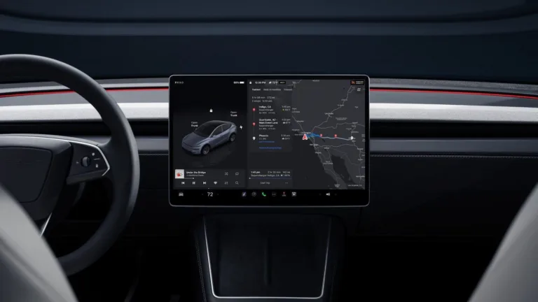 Gros plan sur l’écran tactile central d’un Tesla Model Y affichant la voiture, la musique et la carte