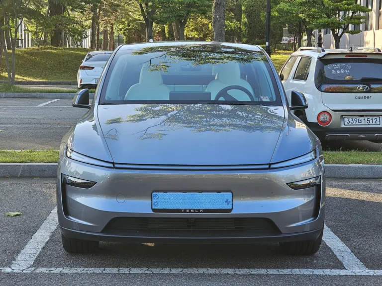Un Tesla Model Y Juniper gris Quicksilver, vu de face sur un parking