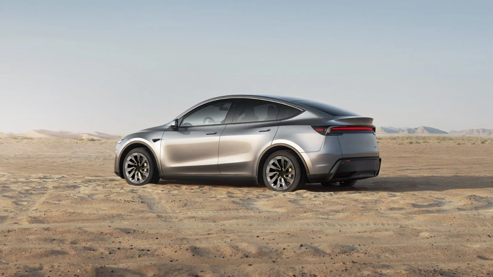 Le Tesla Model Y, voiture électrique la plus vendue en France en septembre 2026, vu de trois quarts arrière sur une piste de sable