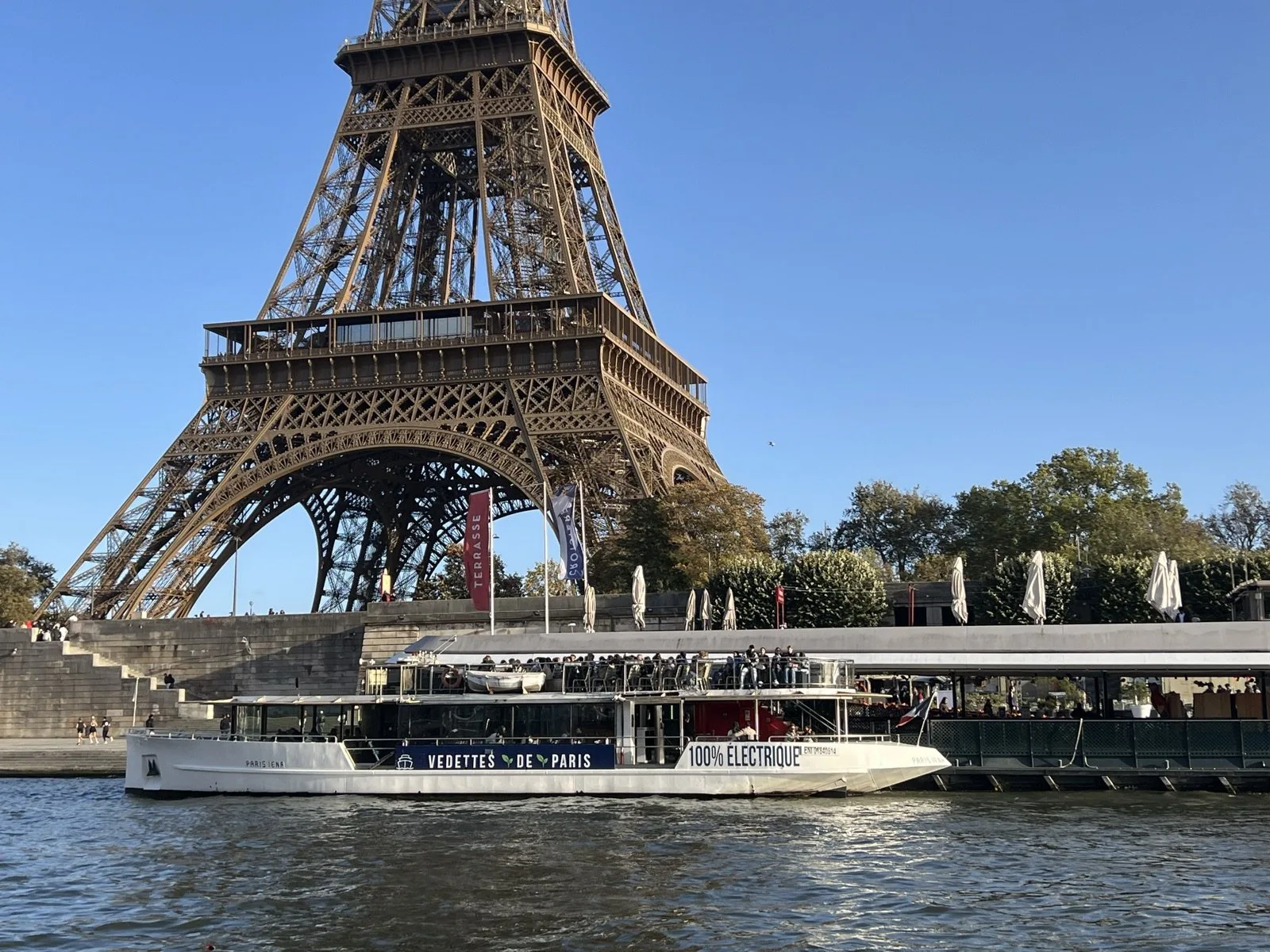 Le bateau Paris Iéna des Vedettes de Paris, marqué 100 % électrique, au pied de la tour Eiffel