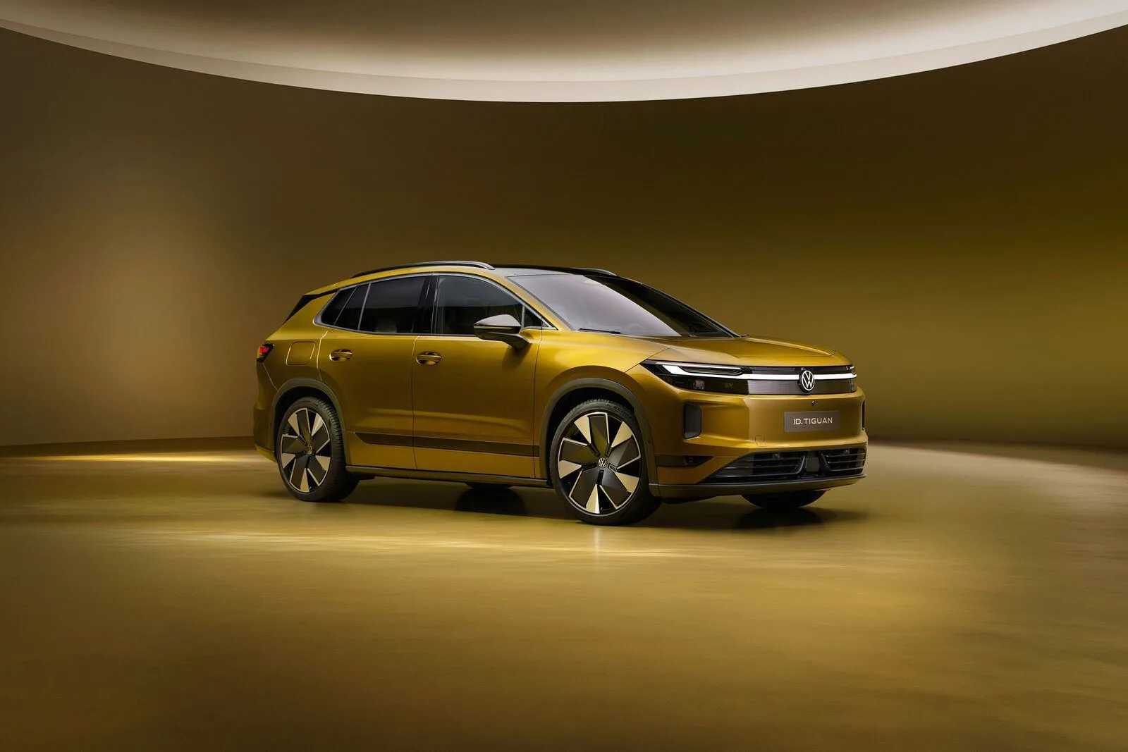 Volkswagen ID. Tiguan électrique doré vu de trois quarts avant dans un studio