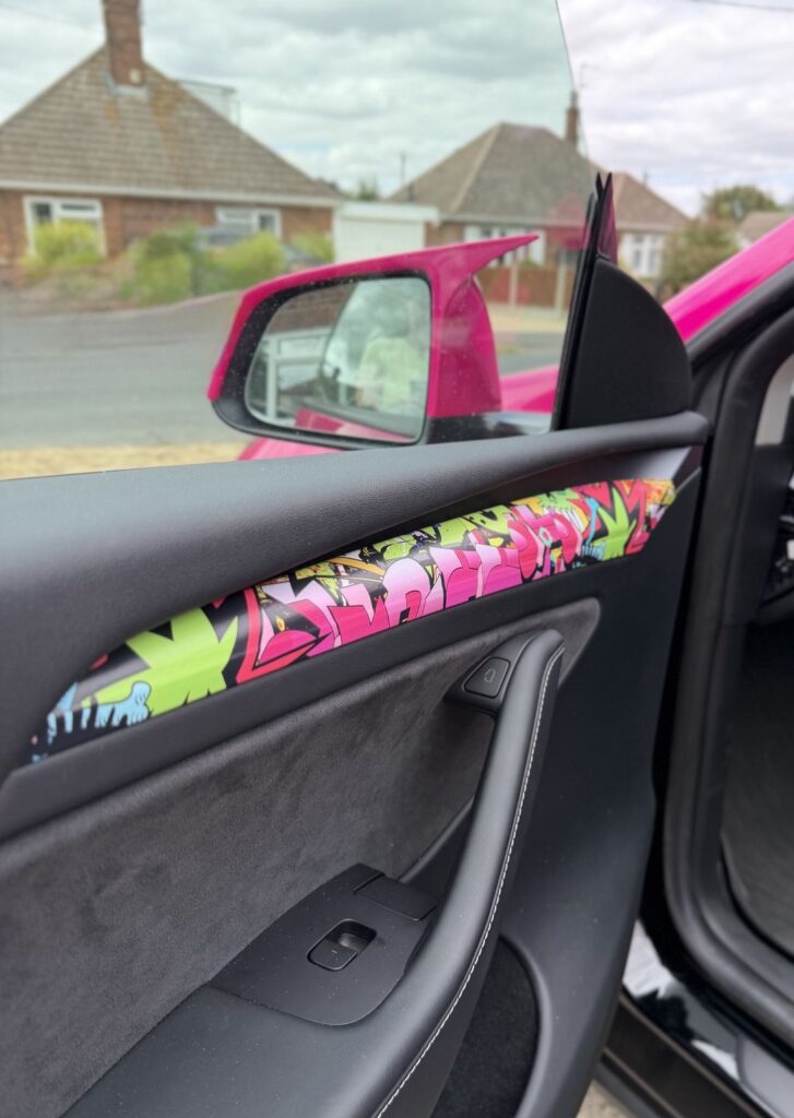 Graffiti-style wrap on the door trim of The Unicorn Tesla