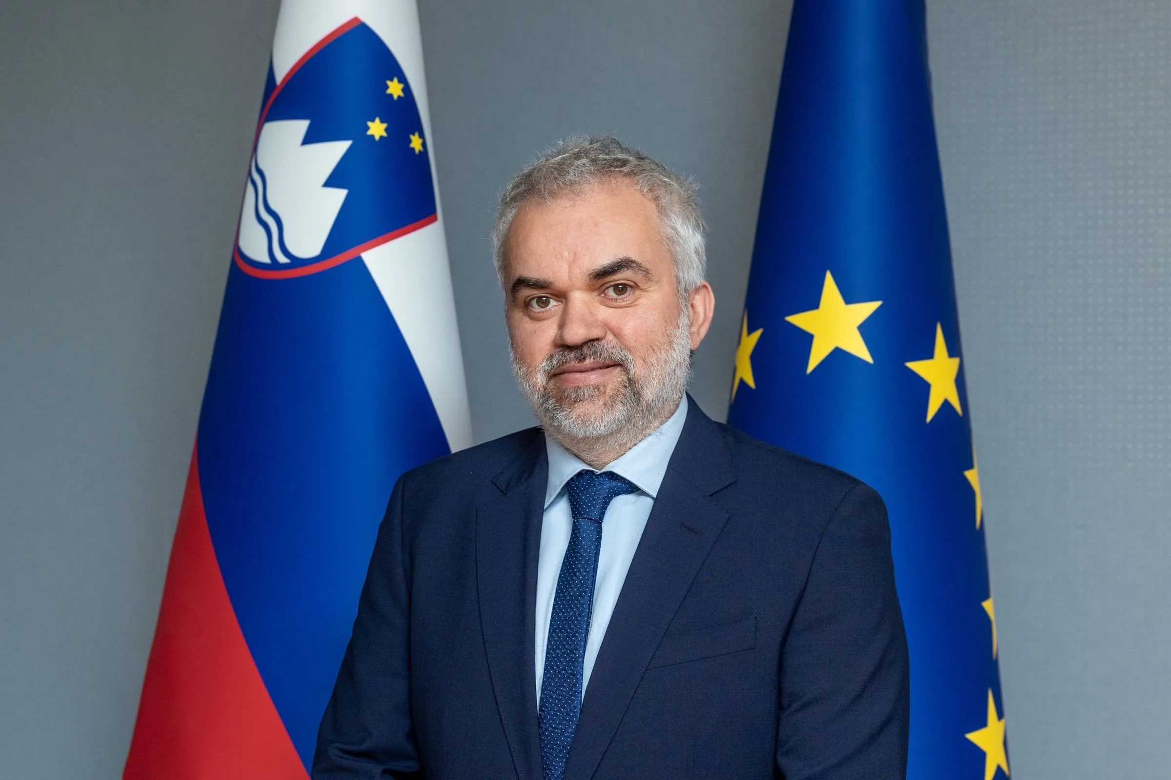 Marko Dvornik, Slovenian State Secretary for Mobility and Transport, in front of the Slovenian and EU flags